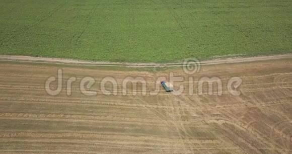 空中全景从无人驾驶飞机以上的农田与移动卡车装载成熟小麦视频的预览图