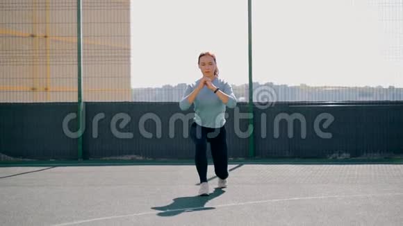 那个女孩在街道上的一个围栏地区参加体育活动街头健身操向前冲视频的预览图