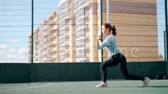 那个女孩在街道上的一个围栏地区参加体育活动街头健身操向前冲视频的预览图