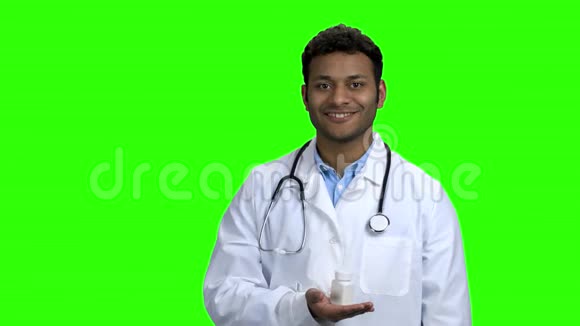 年轻的男医生在绿色屏幕上呈现药丸视频的预览图