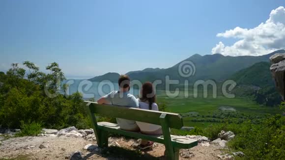 一对夫妇坐在长凳上欣赏湖光山色视频的预览图