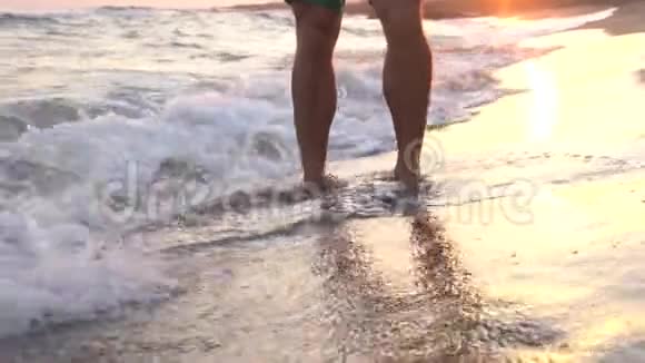 跑步男子在阳光明媚的海滩上做交叉适合的蹲跳视频的预览图