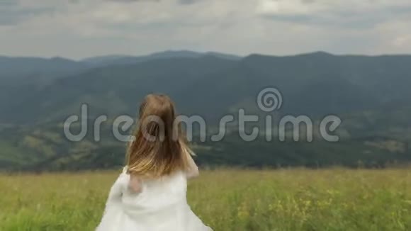 穿着婚纱的美丽新娘穿过群山视频的预览图