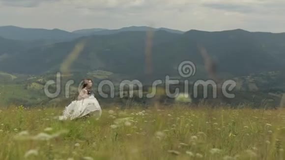 穿着婚纱的美丽新娘穿过群山视频的预览图
