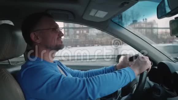 白人司机开车在天桥下微笑冬季城市日落视频的预览图