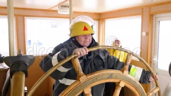女船长在浮船航行桥上转动方向盘女水手驾驶帆船视频的预览图
