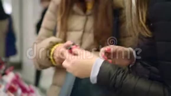 漂亮的年轻女人用手指在嘴唇上涂上新的口红颜色视频的预览图