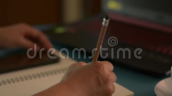 商务女性用笔记本电脑在记事本上写字并在办公桌上喝一杯咖啡视频的预览图