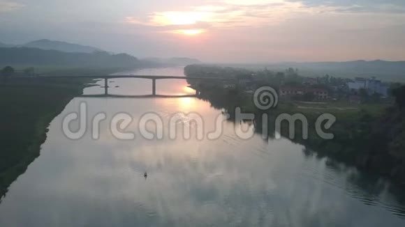 狭窄桥下的热带河流迎着夏日日落视频的预览图
