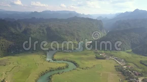 山谷中的波浪状河流与山脉之间的丛林鸟瞰视频的预览图