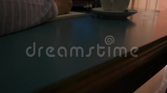 女商人用笔记本电脑在桌子上工作女人的手在记事本上写字在家里喝一杯咖啡视频的预览图