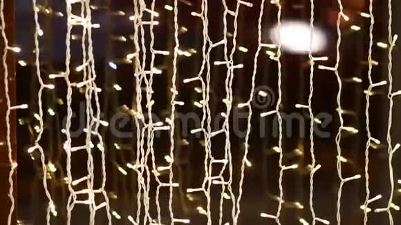一个由微型LED灯泡组成的花环在显示箱的玻璃附近发光视频的预览图