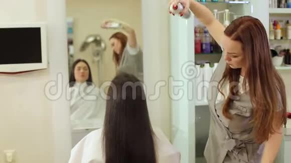美容师溅到女孩的头发保护和保湿喷雾视频的预览图