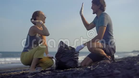 年轻夫妇用垃圾清理海滩视频的预览图