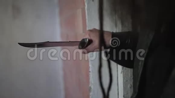 一个穿着黑色雨衣和带着刀的帽子的硬汉站在通道里来到破楼的房间视频的预览图