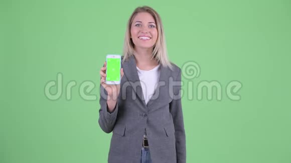 一位年轻的金发碧眼的女商人带着电话竖起大拇指视频的预览图