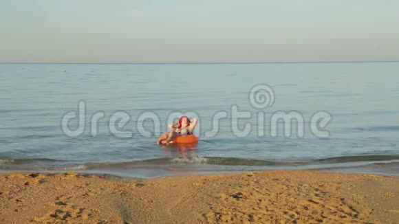 一个穿着泳衣在海浪中红头发的女人视频的预览图