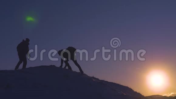 登山者在夕阳的照耀下征服了一座山后举起双手从快乐中跳了出来视频的预览图