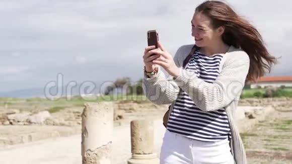 一个年轻的女人走路时在手机上自拍视频的预览图