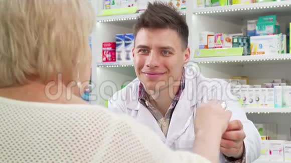 开朗的药剂师向资深顾客推销药物视频的预览图