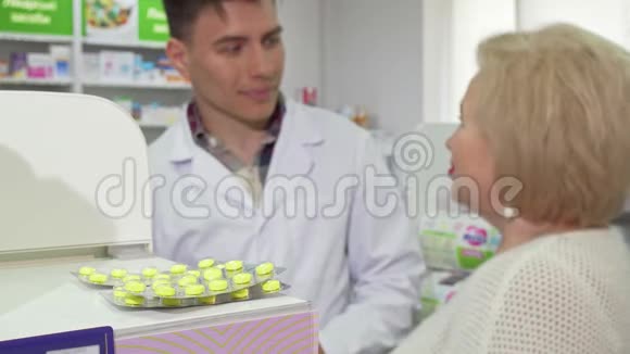 开朗的药剂师提供老年女性顾客服药视频的预览图