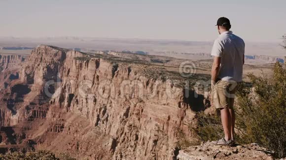 快乐成功的年轻游客在大峡谷山脉上观看史诗般的风景宽的电影背景拍摄视频的预览图
