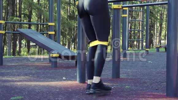 在户外用弹力带做运动的女性腿部特写视频的预览图