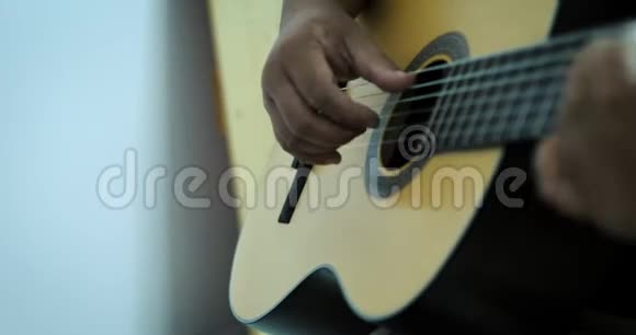 音乐艺术家演奏声学经典吉他与黑暗和谷物加工视频的预览图
