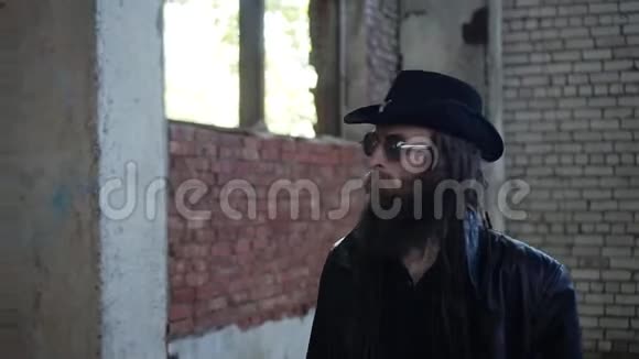 戴着黑色斗篷和帽子的凶手进入了一家废弃工厂的领地视频的预览图