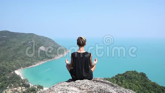 短发的年轻女子正坐在悬崖边上看风景视频的预览图