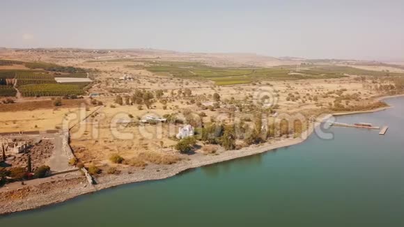 在卡珀纳姆湖上的一只野娃娃岸边景12个使徒的东正教教堂加利利海海岸俯视视频的预览图