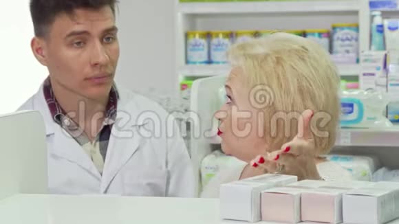 老年妇女向药剂师请教在药店购物视频的预览图