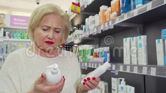 可爱的老太太微笑着在药店的两种产品中选一种视频的预览图