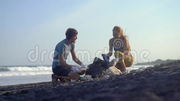 年轻夫妇用垃圾清理海滩视频的预览图