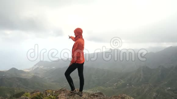 年轻女子站在山顶上的仙人掌和热带植物在美丽的风景夫人在视频的预览图