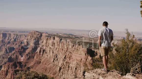 快乐兴奋的年轻男子惊讶于史诗般阳光明媚的夏天全景著名的大峡谷国家公园在亚利桑那州美国视频的预览图