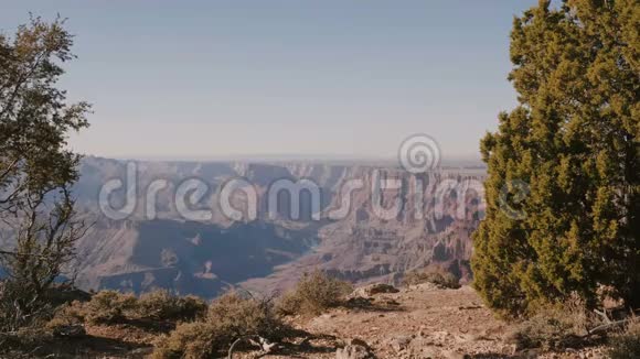 在美国大峡谷的壮丽夏日热景中快乐活跃的年轻游客骑着相机走到一边视频的预览图
