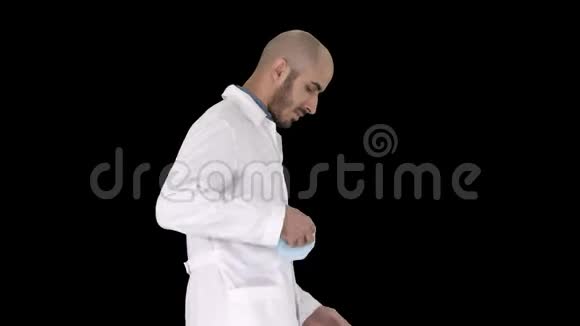 阿拉伯医生走路戴上医疗帽阿尔法频道视频的预览图