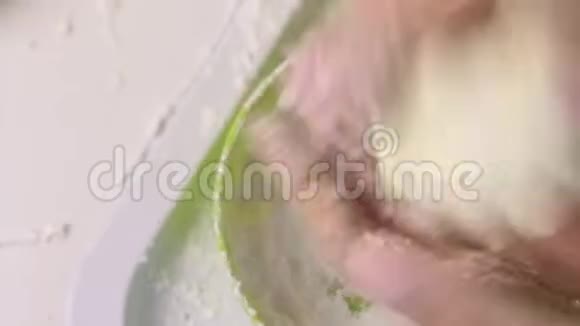 一个女人在糖霜中以玫瑰的形式卷棉花糖桌子表面附近有一个现成的棉花糖视频的预览图