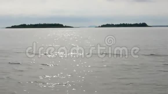 沿着水面湖面右向左移动有小岛和蓝天的景色视频的预览图