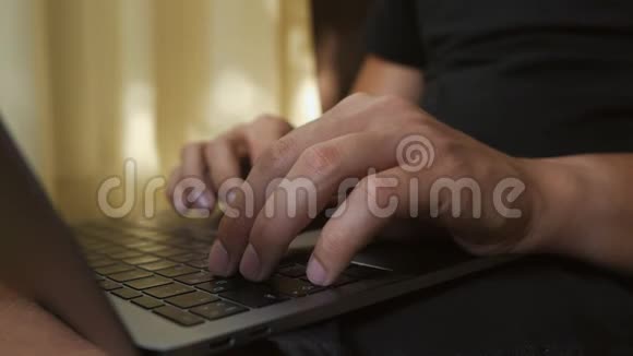 一个男人的手笔记本电脑的键盘上一个年轻人坐在地板上用电脑工作视频的预览图