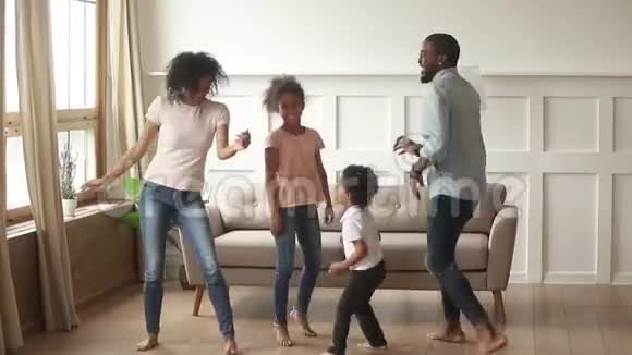 一对非洲夫妇的小孩在家里积极地跳舞视频的预览图