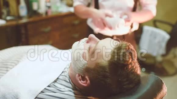 理发师用泡沫或剃须膏客户的胡须视频的预览图