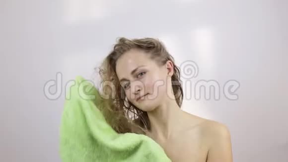女人用浅绿色毛巾擦干头发视频的预览图
