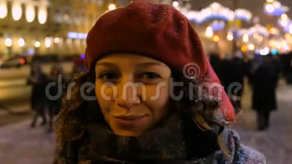 夜晚城市冬天一个美丽女孩的肖像背景中的人群和汽车视频的预览图