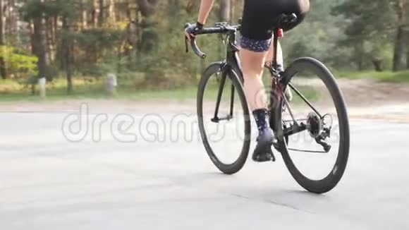 性感的女骑自行车的人从公园的马鞍上蹬出来自行车上的艰苦训练公路自行车概念慢动作视频的预览图