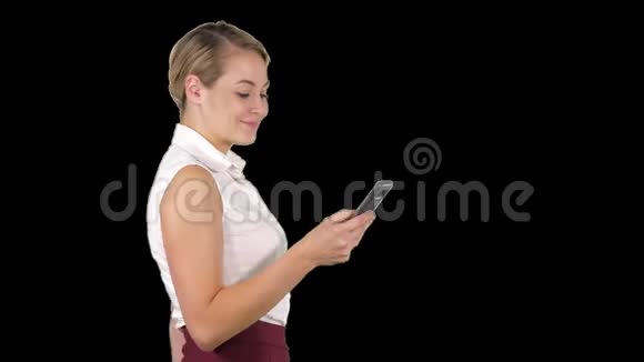 一半长的照片年轻女商人看她的手机阿尔法频道视频的预览图