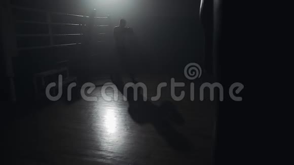 男拳击手在黑暗中训练慢动作剪影拳击概念视频的预览图