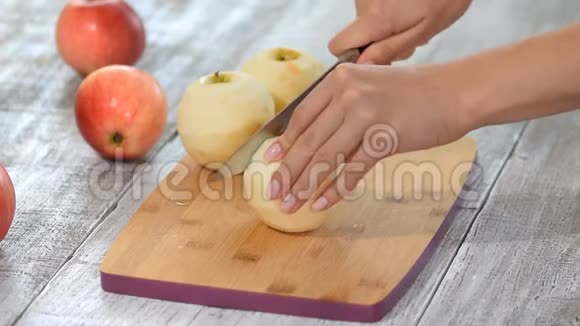国产厨房木切板上用刀切苹果的女性手特写视频的预览图