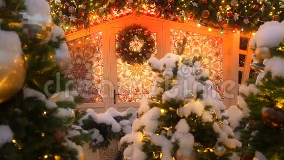 圣诞枞树花圈挂在一座漂亮的房子的门上窗户上挂着装饰品和圣诞花环视频的预览图